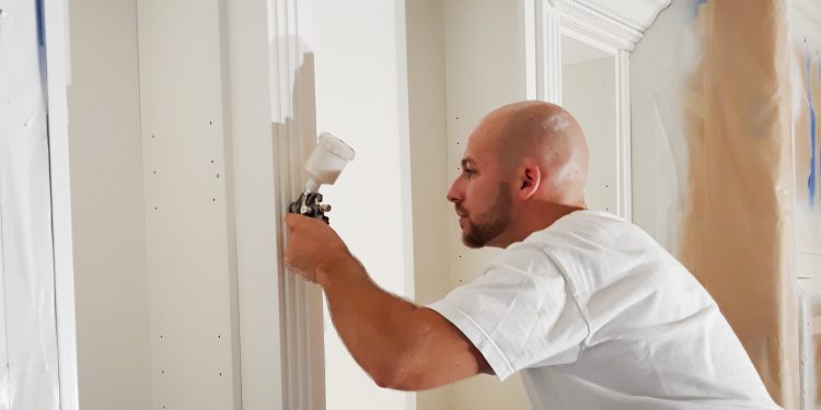 Professional kitchen cabinet painter applying finish to white kitchen cabinets in Charlotte NC