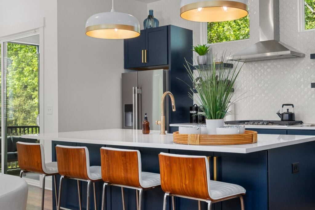 Kitchen with a navy island, white countertops and a herringbone tile backsplash