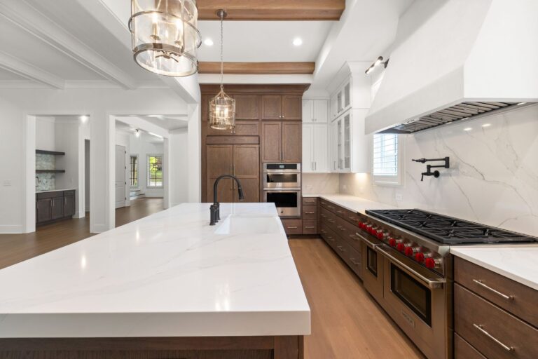 Example of a kitchen with white quartz countertops and a slab backsplash