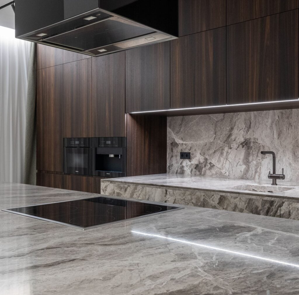 Quartzite countertops with a matching slab backsplash in a white kitchen