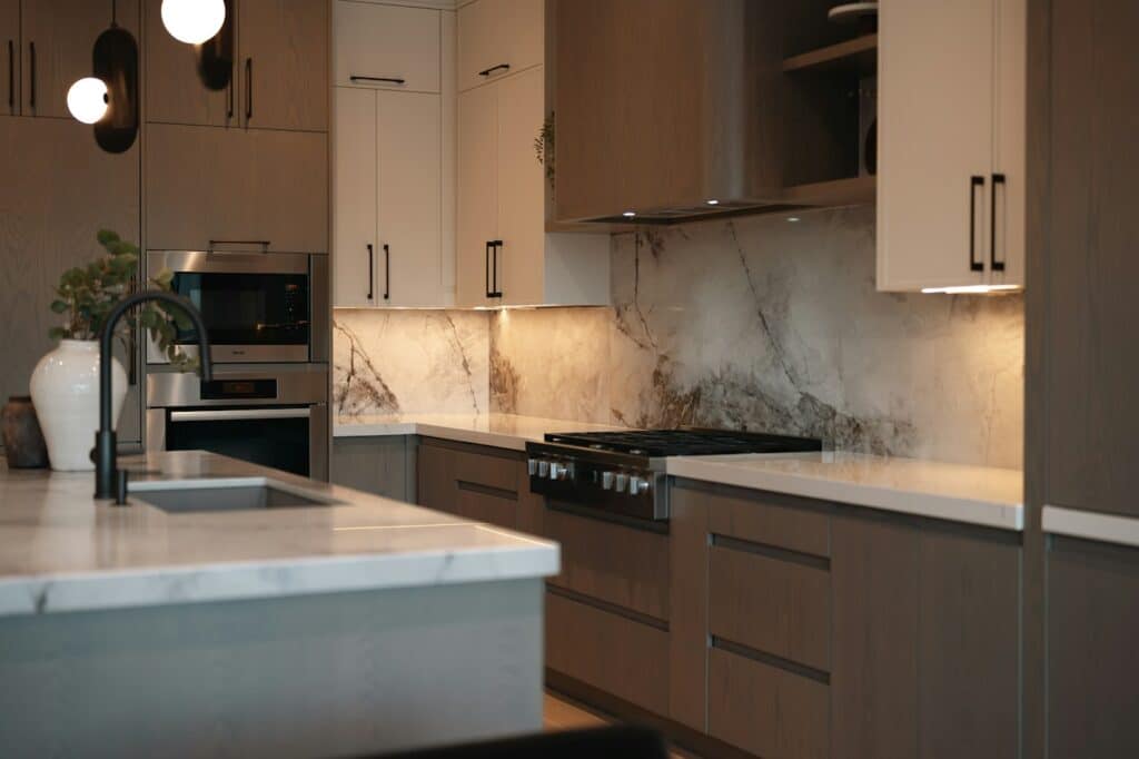 Kitchen with a warm veined stone backsplash and two-tone cabinets
